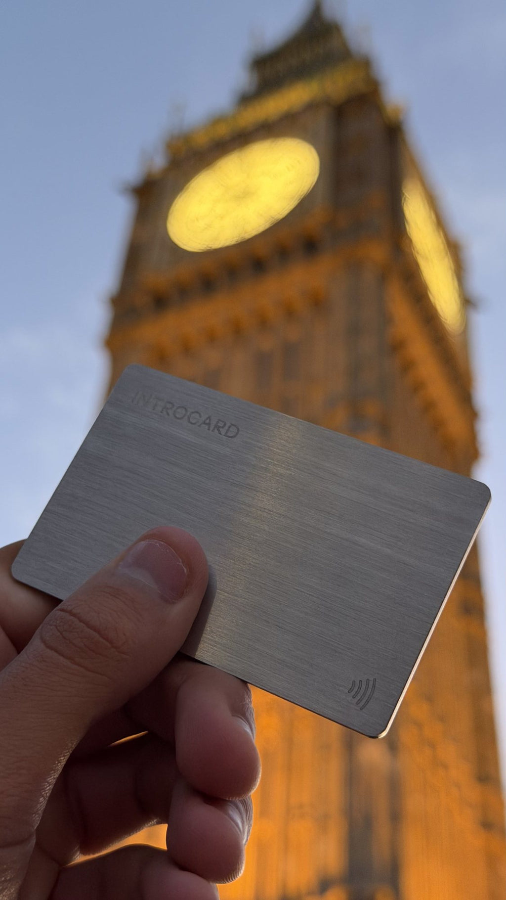 Introcard held in front of the Elizabeth Tower in London at dusk