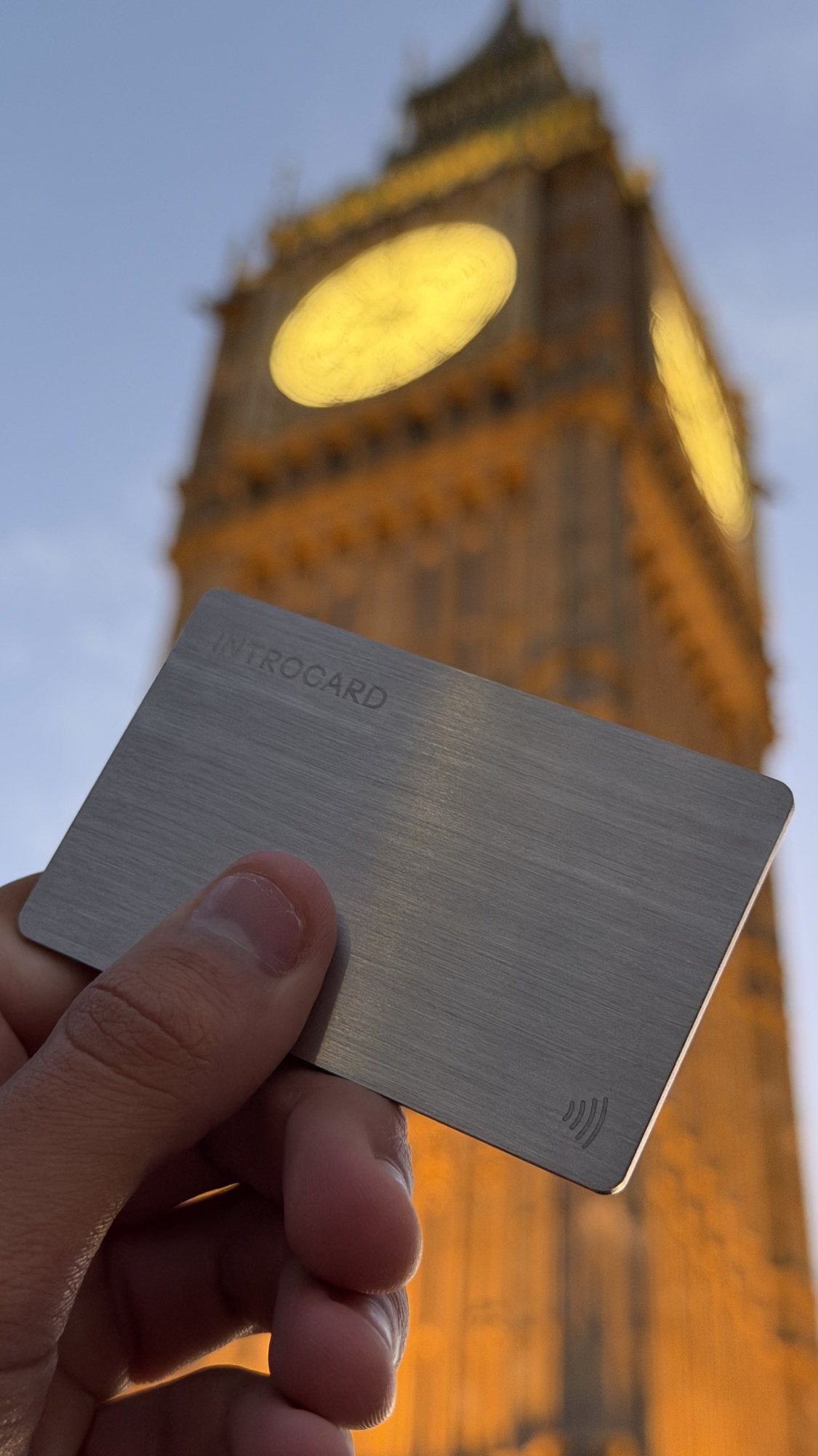Introcard held in front of the Elizabeth Tower in London at dusk