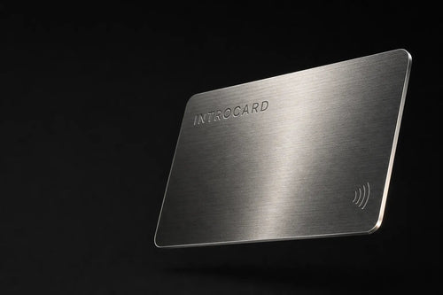 Burnished silver Introcard with laser-engraved wordmark and contactless symbol, floating against black